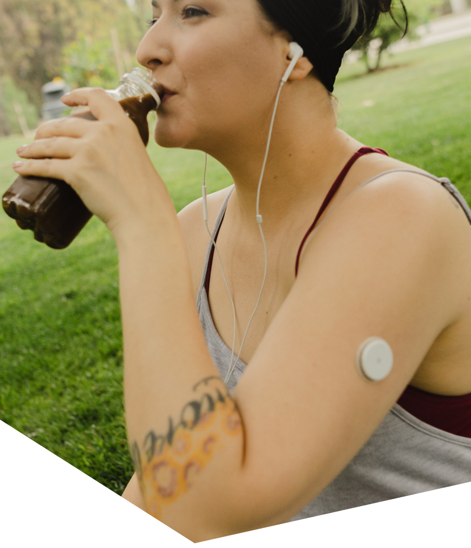 Woman wearing a glucose sensor while exercising outdoors, part of diabetes lifestyle support